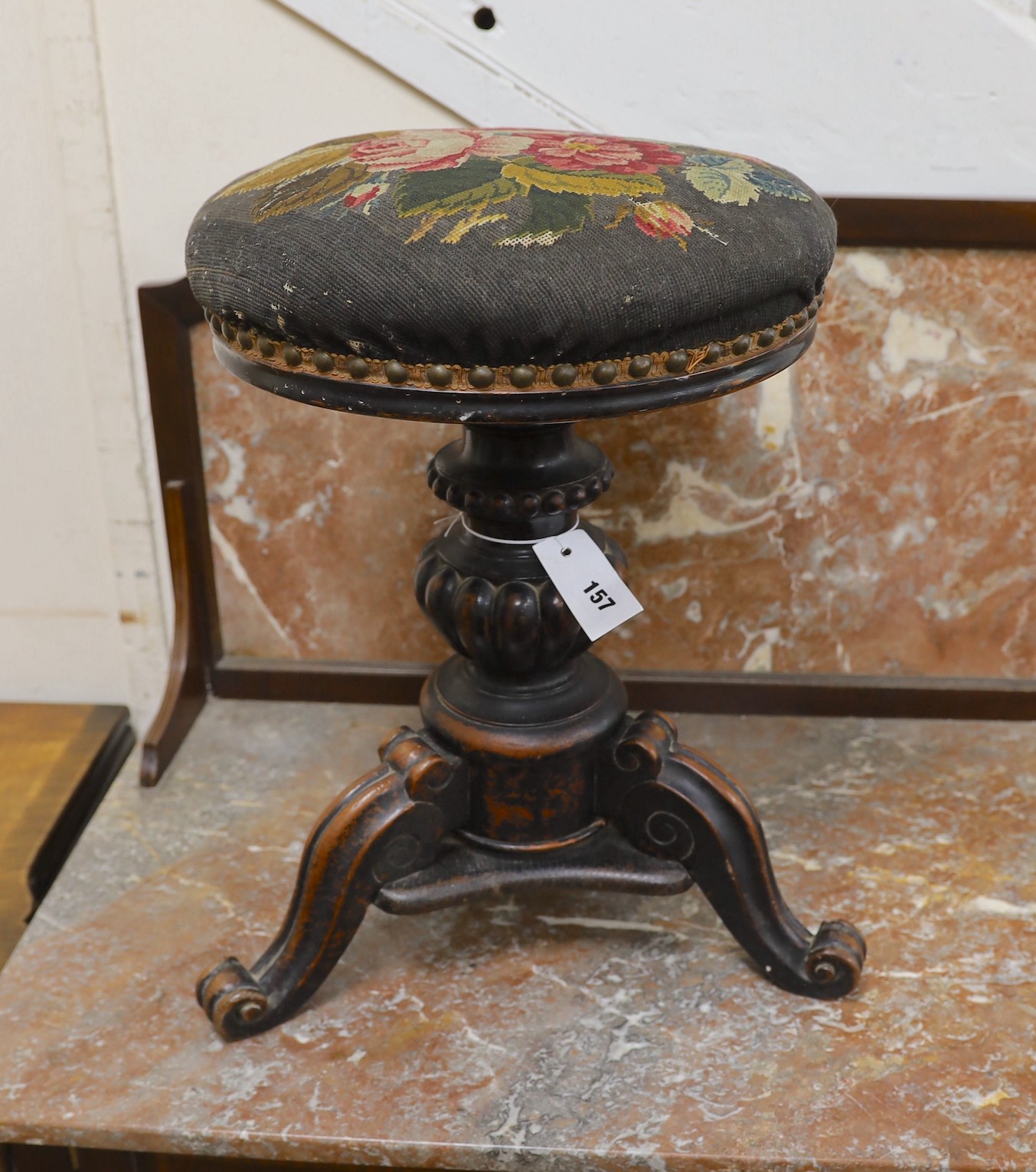 A Victorian mahogany adjustable revolving piano stool with tapestry seat